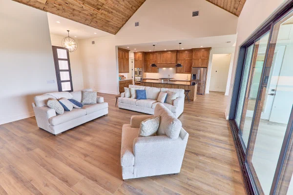 Cathedral wood ceiling crowns the great room of a Texas Hill Country custom home with oak kitchen beyond
